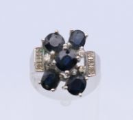 An 18 K white gold sapphire and diamond ring. Ring size L. 6.8 grammes total weight.