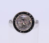 An Art Deco unmarked white gold diamond and onyx cluster ring. Total diamond weight approximately 1.