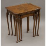 A nest of three walnut tables. The largest 54 cm wide.
