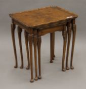 A nest of three walnut tables. The largest 54 cm wide.