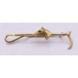 A 9 ct gold bar brooch formed as a riding crop and horse's head with gem set eye. 6 cm long. 6.