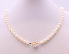 A single strand pearl necklace with a 14 ct gold clasp. 88 cm long.