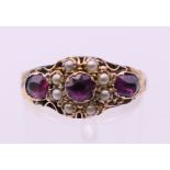 An antique 9 ct gold garnet and seed pearl ring. Ring size O. 1.9 grammes total weight.