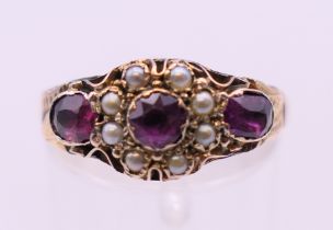 An antique 9 ct gold garnet and seed pearl ring. Ring size O. 1.9 grammes total weight.