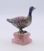 An unmarked silver and enamel gem set model of a goose mounted on a rose quartz stepped plinth base.