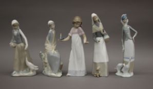 Two Lladro figurines and three Nao figurines. The largest 27 cm high.