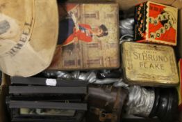 A box of miscellaneous items, including binoculars, tins, a pith helmet, etc.