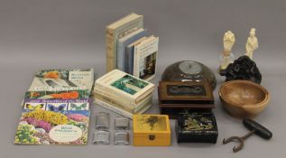 A box of miscellaneous items, including boxes, a barometer, books, etc.