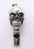 A silver skull shaped whistle. 4 cm high.