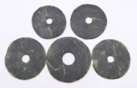 Five Chinese dark green jade bi discs of various sizes, Neolithic Period. The largest 7.