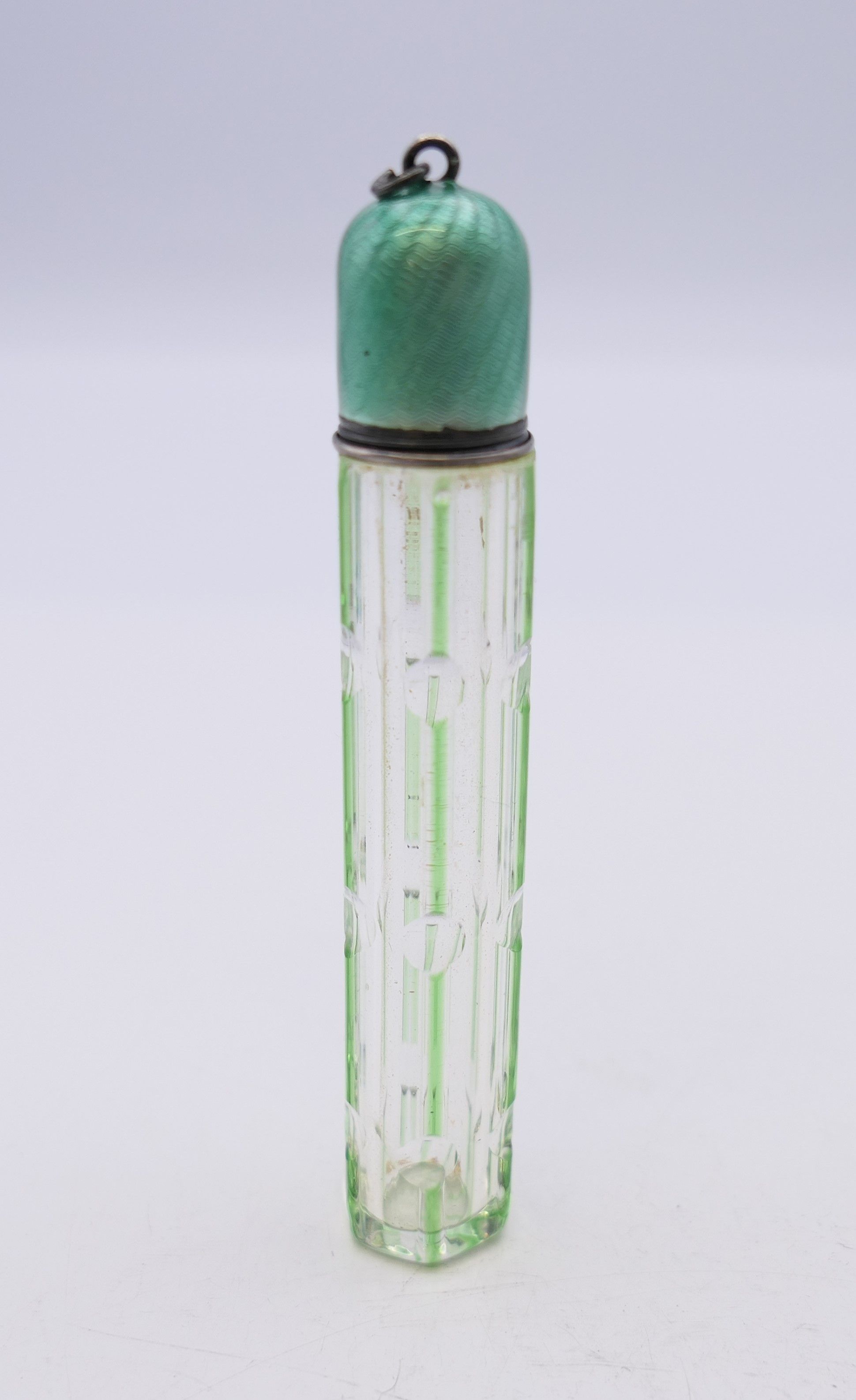 A green overlay glass scent bottle with enamel lid. 8 cm high.