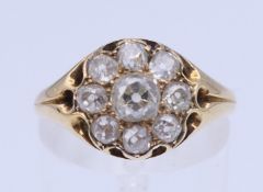 An unmarked gold and diamond cluster ring. Ring size O/P. 3.2 grammes total weight.