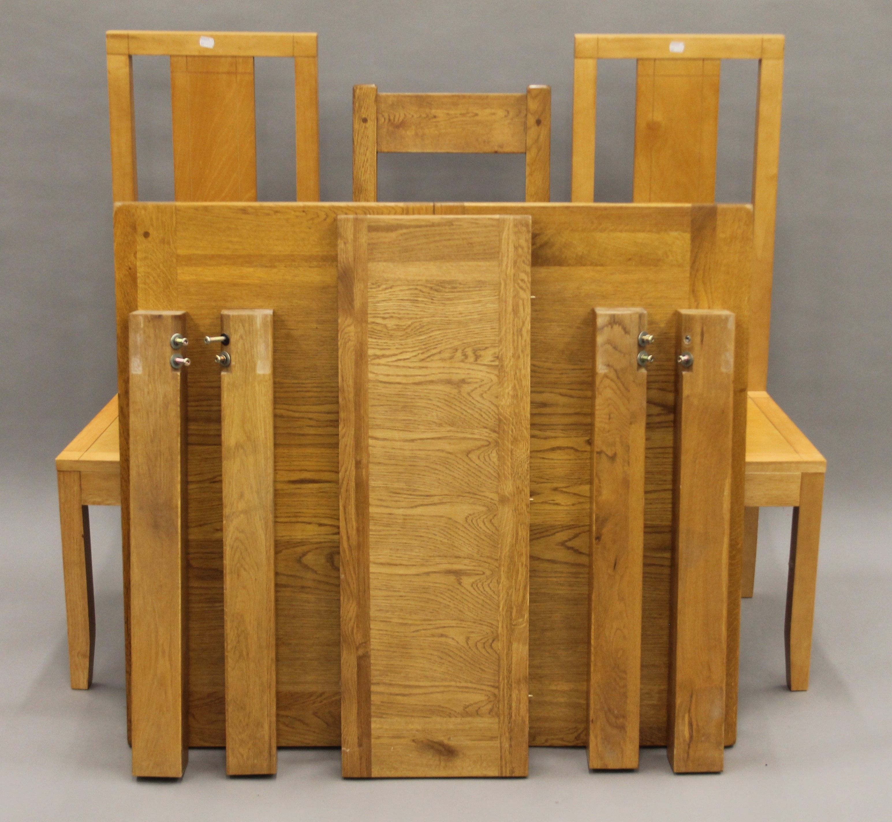 A modern oak extending table and three chairs. The table 130 cm long extended.