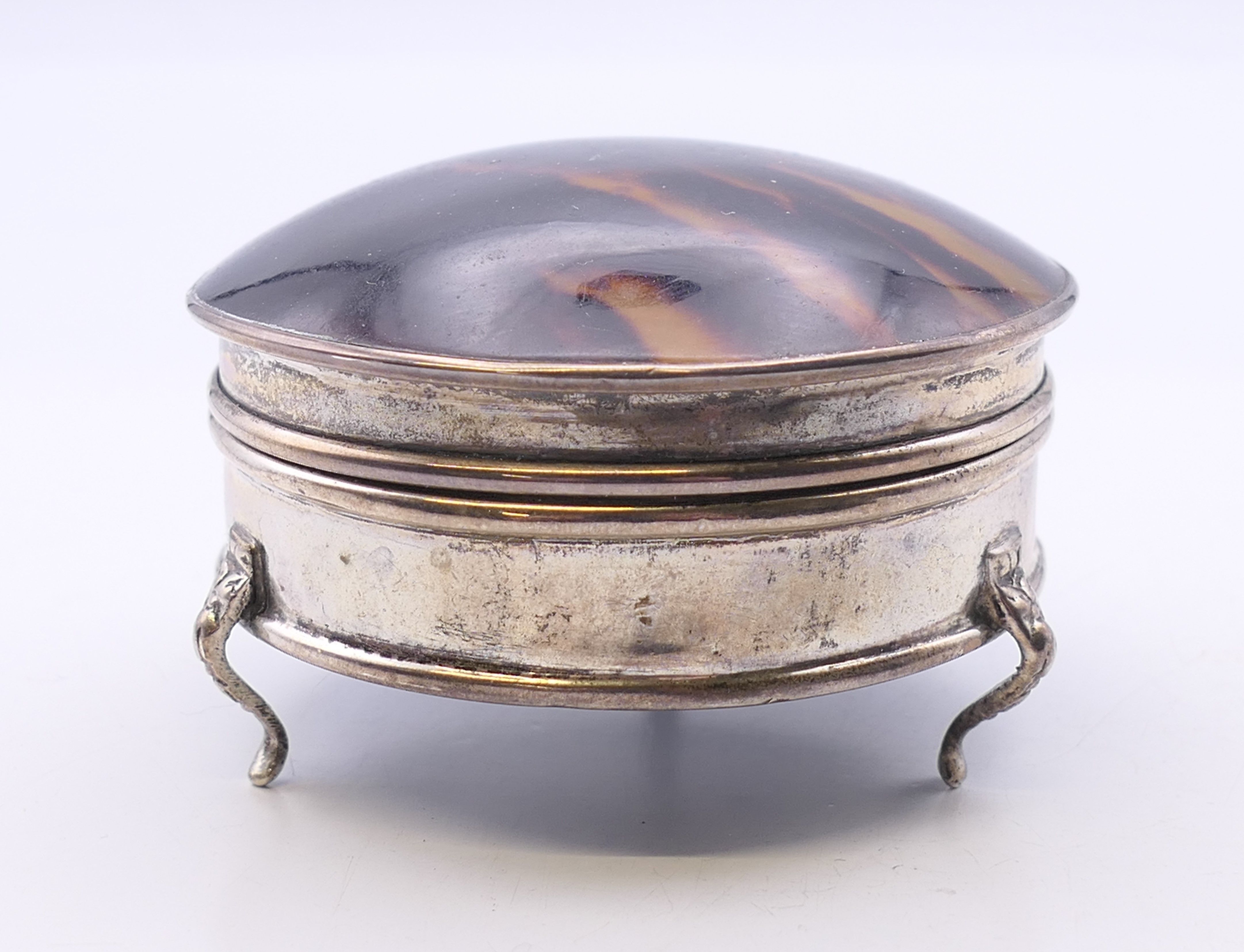 A tortoiseshell lidded silver jewellery box. 7 cm diameter.