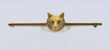 A 9 ct gold fox mask bar brooch with gem set eyes. 6 cm wide. 4.9 grammes total weight.