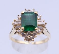 An unmarked gold emerald cluster ring. Ring size S/T. 6.2 grammes total weight.