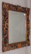 A 19th century carved walnut wall mirror decorated with putti, flowers, fruit and scroll work.