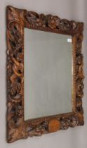 A 19th century carved walnut wall mirror decorated with putti, flowers, fruit and scroll work.