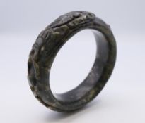A Chinese jade bangle with carved dragon, Qing Dynasty. 6 cm diameter.