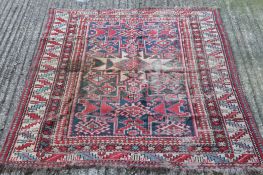 A Caucasian red ground wool rug. 167 cm x 121 cm.