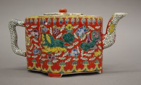 A Chinese teapot, the body decorated with temple lions, flowers, etc.