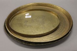 A Chinese engraved brass tray and two Eastern brass trays. The former 32 cm wide.