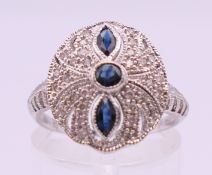 A 14 ct white gold, diamond and sapphire cluster ring. Ring size M/N. 3 grammes total weight.