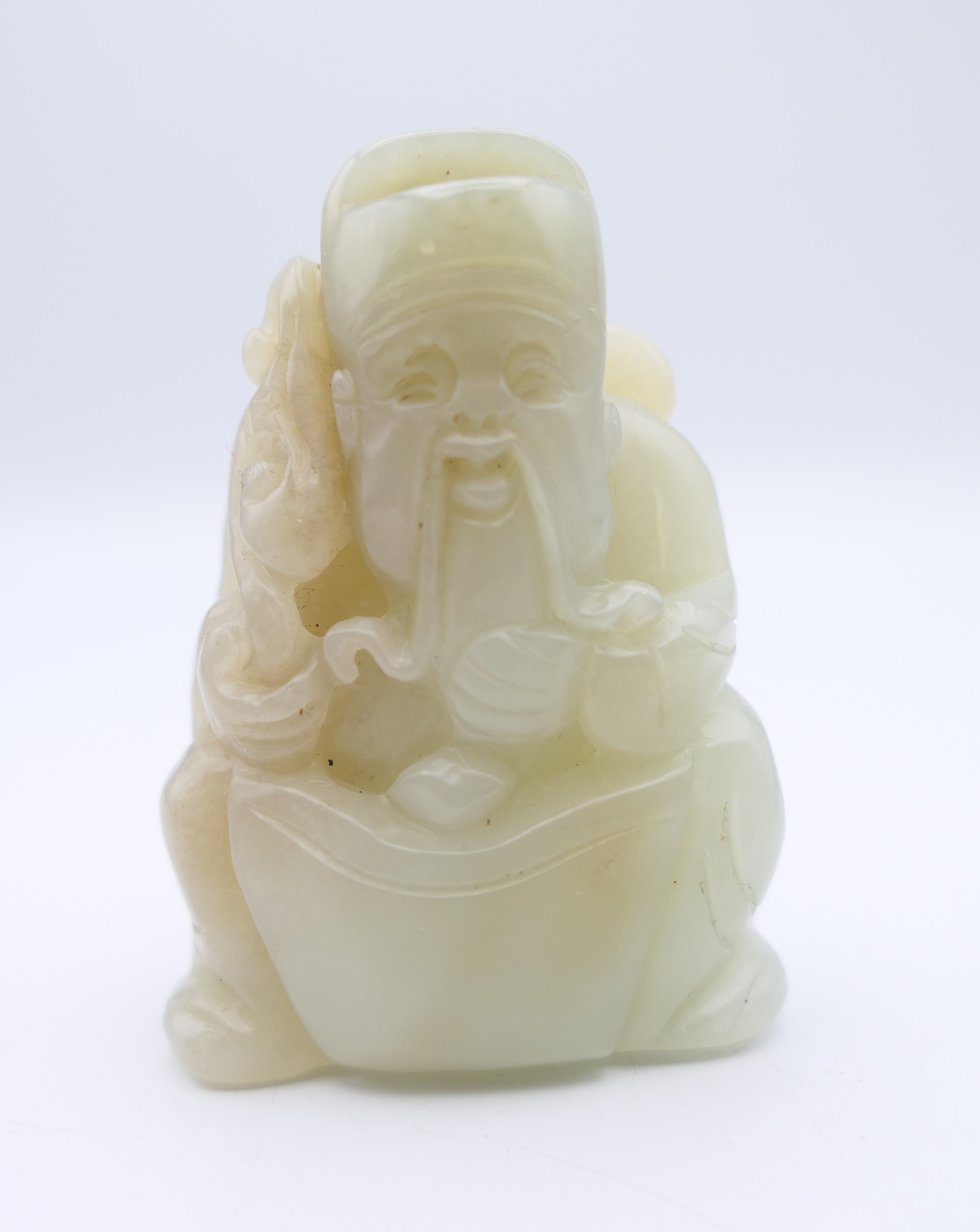 A Chinese light green jade carved figure of an old man, Qing Dynasty. 5.5 cm high.