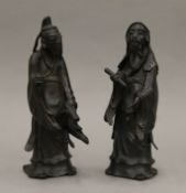 A pair of 17th/18th century Chinese bronze figures of scholars. The largest 24 cm high.