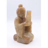 A Chinese light green and russet jade figure of a man playing a sheng and wearing a hair crown,
