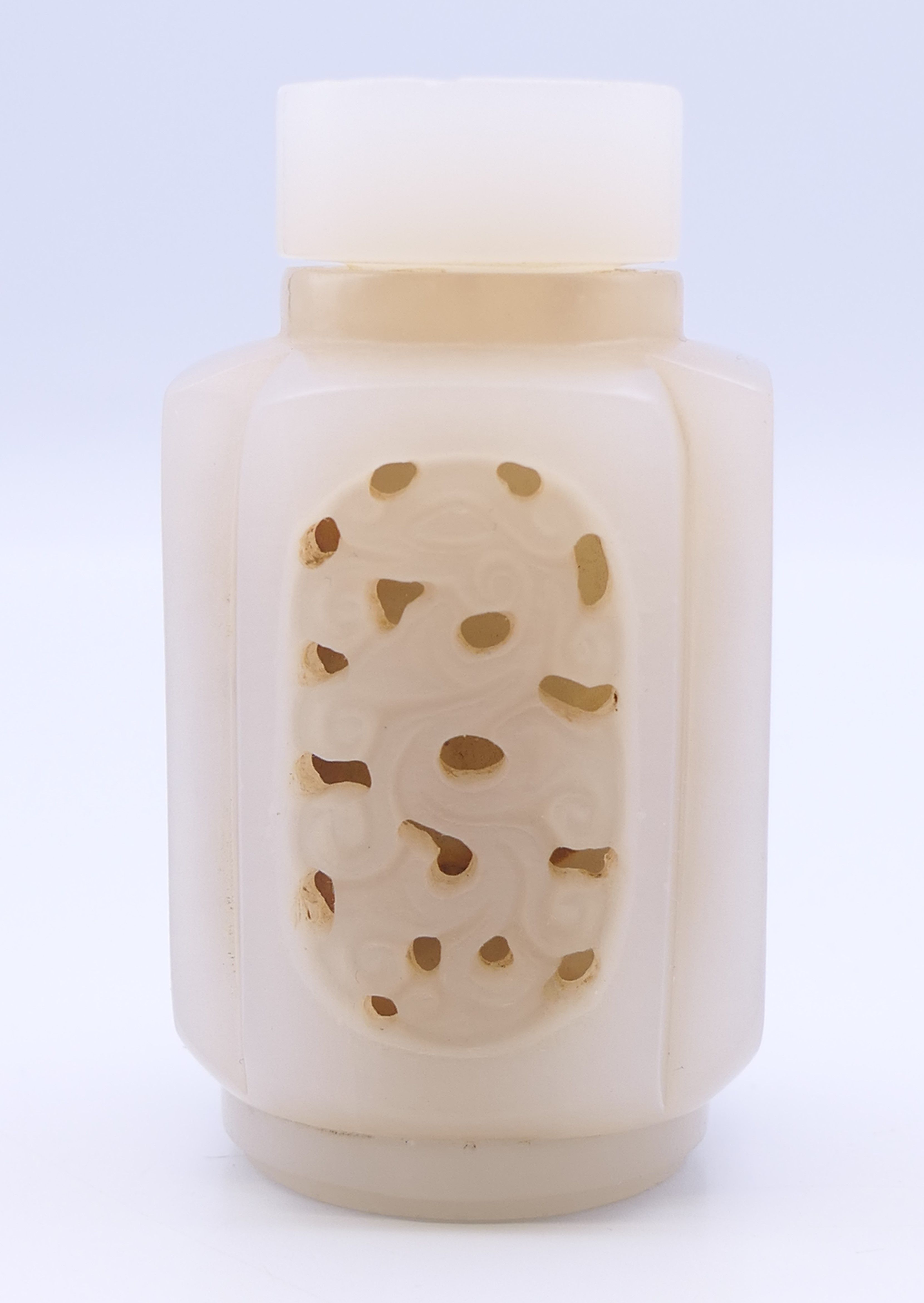 A Chinese light pink and white reticulated jade snuff bottle (stopper missing), Qing Dynasty. 6.