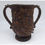 Folk Art Papier Mache loving cup, shaped body applied with leafage, two scroll handles on beaded