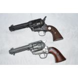 2 replica metal Colt revolvers, a 44 and 45. The black 44 with working mechanism, the silver 45