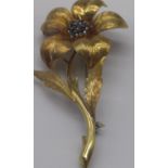 18ct yellow gold brooch in the form of a flower, the centre set with seven sapphires, stamped 18,