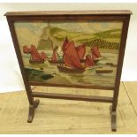C20th oak framed fire screen with inset needle work panel of fishing vessels