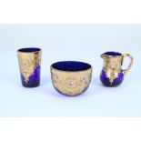 Early C20th Bohemian blue glass and gilt enamel miniature jug, bowl and beaker set in the manner