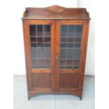 Small C20th oak bookcase, raised back above two part lead glazed doors, on bracket feet, W69cm D25cm