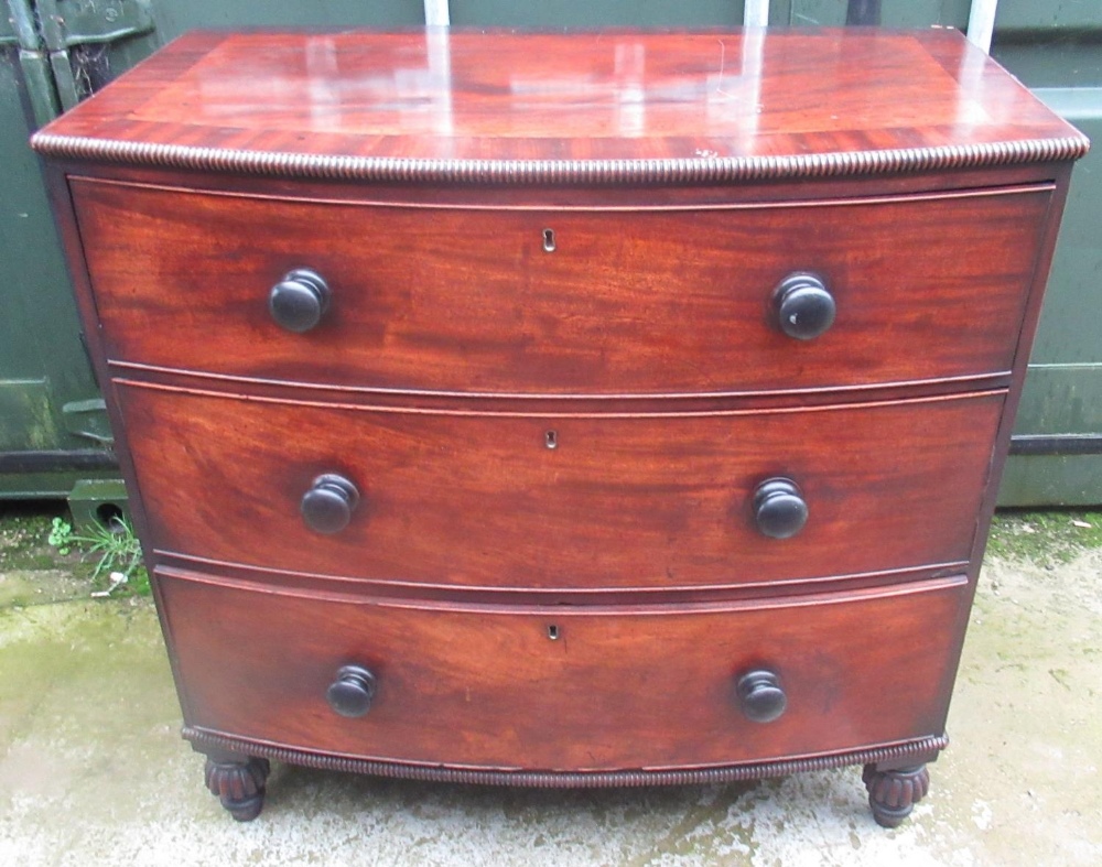Early Victorian mahogany bow front chest of three drawers, figured and crossbanded top, turned