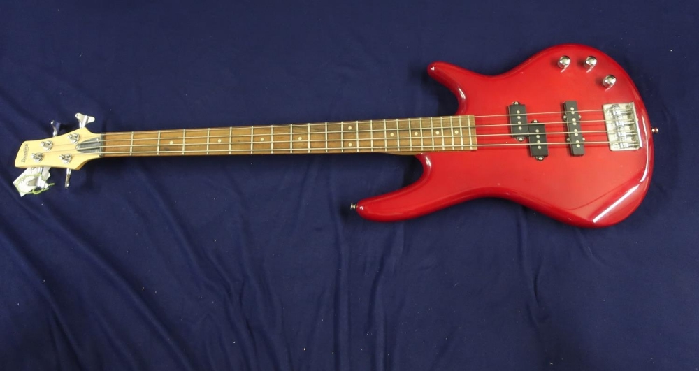 Electric bass guitar with solid body in red finish, with maple neck marked Ibanez on head stock,