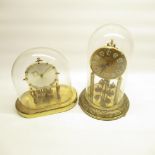2 Kundo brass suspension clocks under glass domes, respective heights are 31cm and 24cm