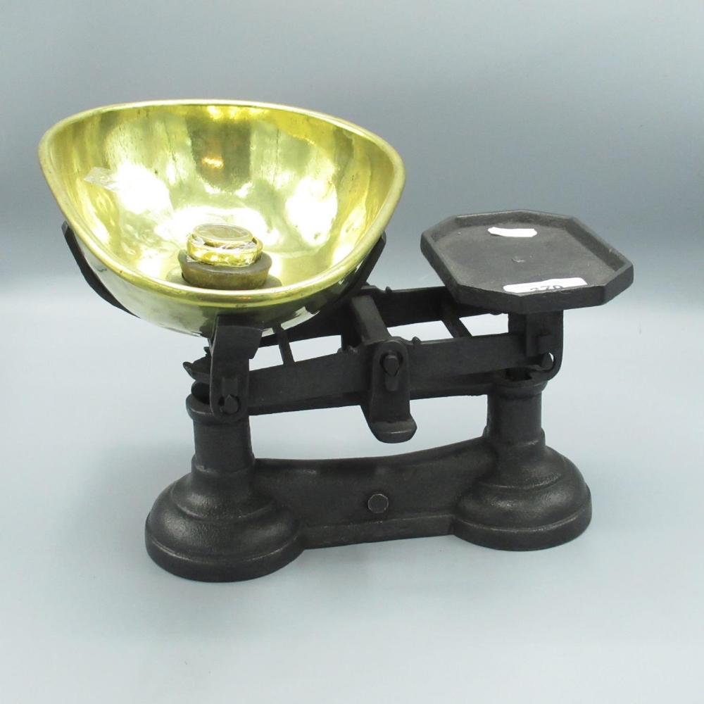 C20th cast iron kitchen scales, with brass pan and four graduating weights, overall W27cm