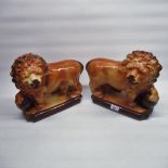 Pair of late C19th models of lions, paw resting on ball L29cm (2)