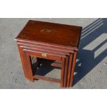 Nest of four Eastern hardwood occasional tables, inlaid with scrolled brass work and flowers max