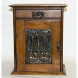 C20th century Art Nouveau oak smoker’s cabinet, embossed copper panel of stylised flowers to door