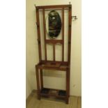 C20th oak mirror back hall stand, 6 metal hooks and 2 swivel metal hooks, above two umbrella and