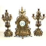 Early 20th century brass clock garniture, comprising central clock in extensively cast brass case