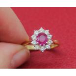 18ct yellow gold cluster ring set with central ruby surrounded by brilliant cut diamonds, stamped