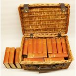 Wicker picnic basket containing 16 Charles Dickins novels published by Oldhams Press Limited