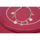 9ct yellow gold chain link bracelet, clasp stamped 375, with attached yellow metal charms, gross 7.