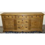 Stewart Linford Furniture - an oak low dresser, moulded top above five drawers and two fielded panel